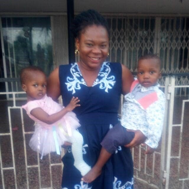 A caregiver carrying two toddlers at the home